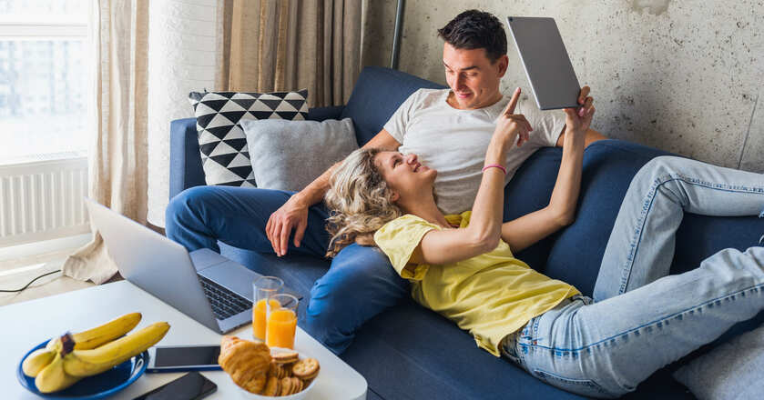 casal rindo no sofá