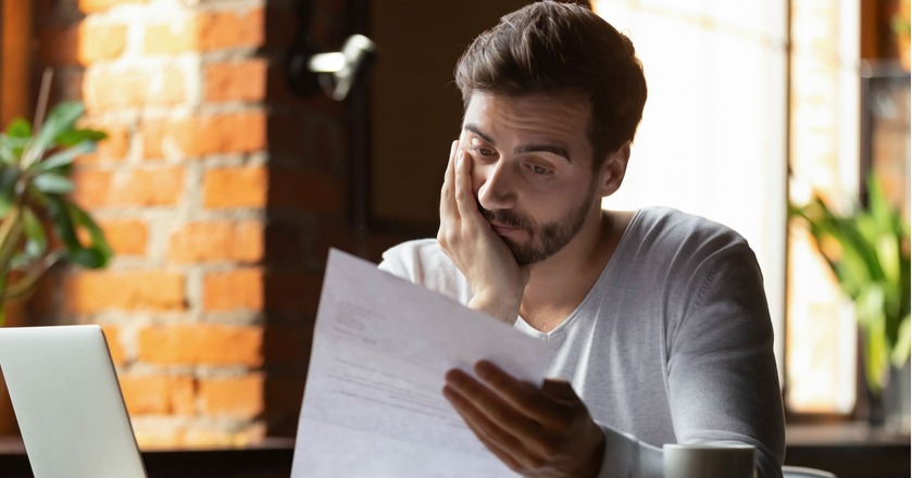 dívida caduca homem aflito com um papel na mão