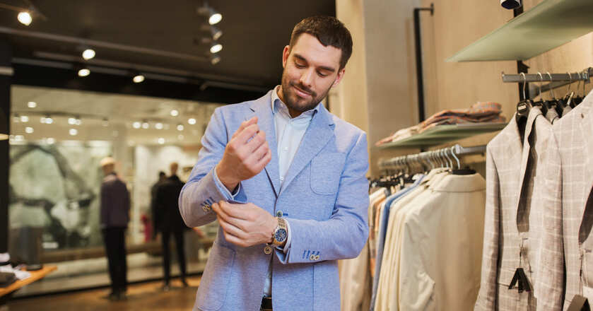 Homem ajustando manga do terno em loja