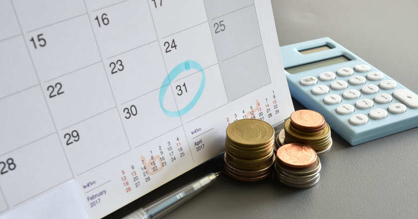 Moedas ao lado de calendário marcando o dia 31