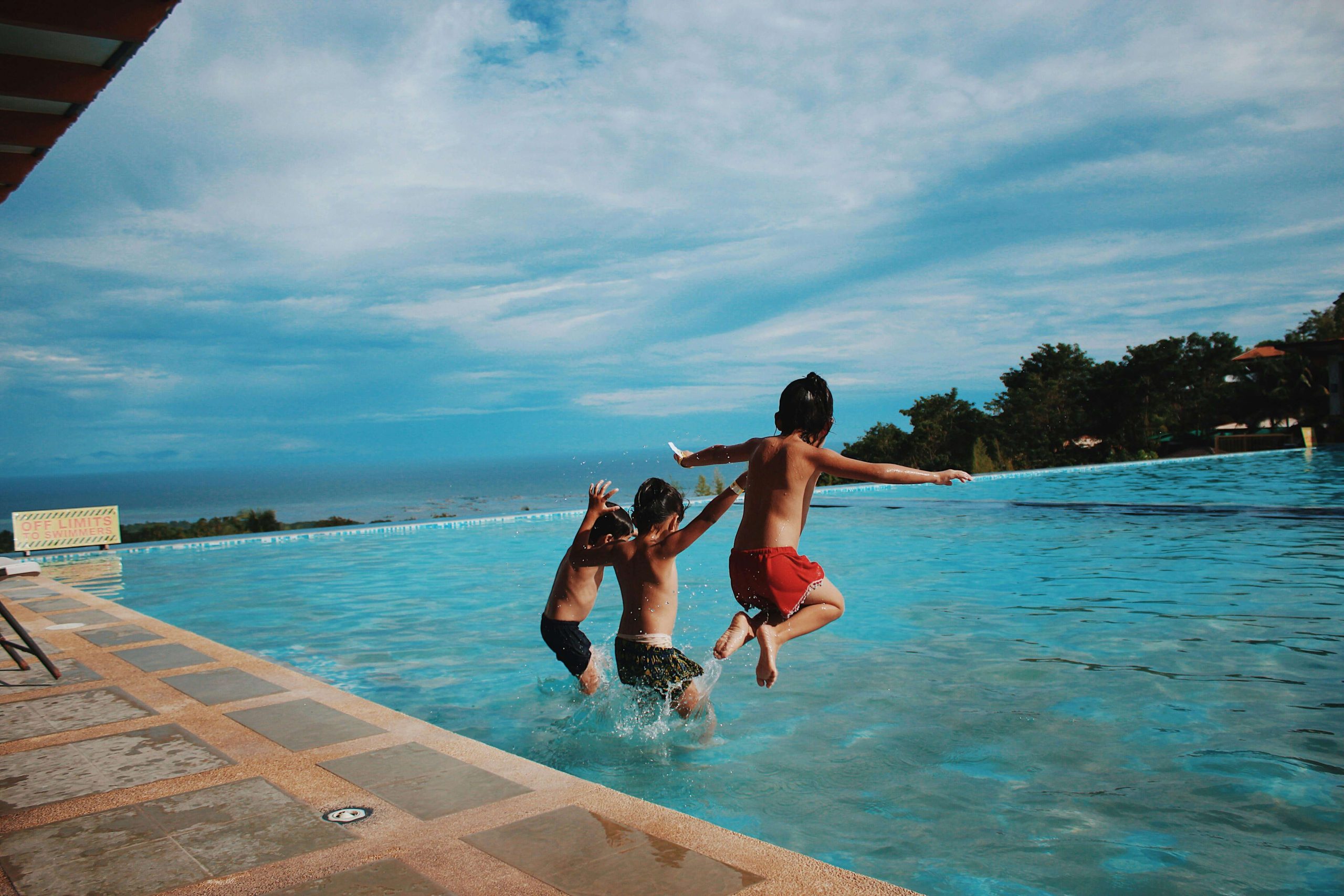 Crianças decidem pular na piscina nas férias