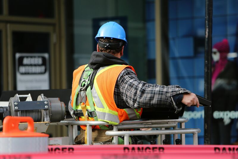 Trabalhador de construção com capacete e colete refletivo.