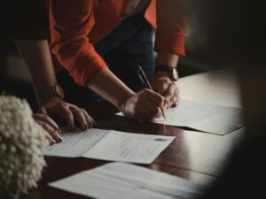 Pessoa assinando documentos para representar planejamento sucessório e previdência privada