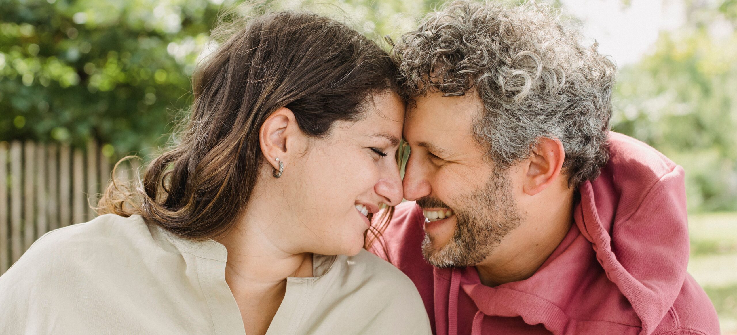Casal sorrindo planejando contratar um Seguro de Vida.